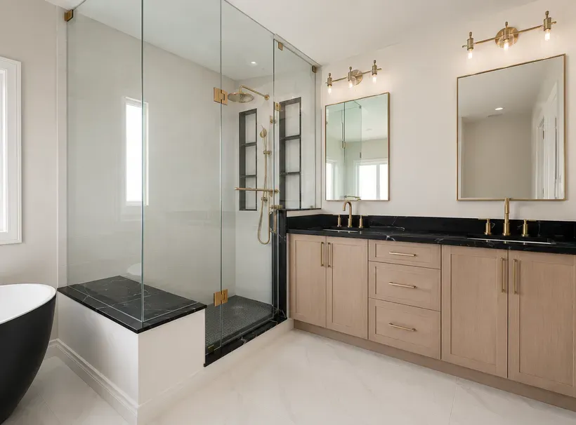 Custom bathroom vanity cabinetry with a glass shower and gold hardware in Sarasota, FL