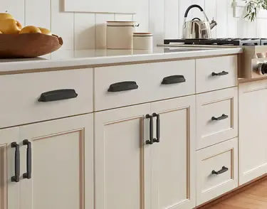 New cabinet hinges and handle hardware on white cabinets in Sarasota, FL
